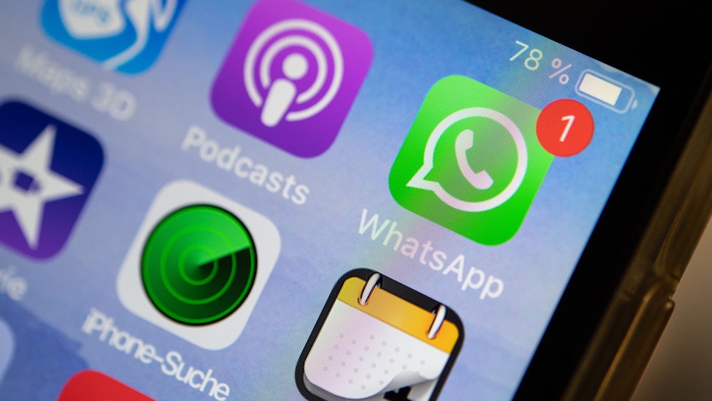 Das Logo der Messenger-App WhatsApp ist auf dem Display eines iPhones zu sehen (Symbolfoto). Für Sprachfunktionen soll es bei WhatsApp bald eine neue Funktion geben.