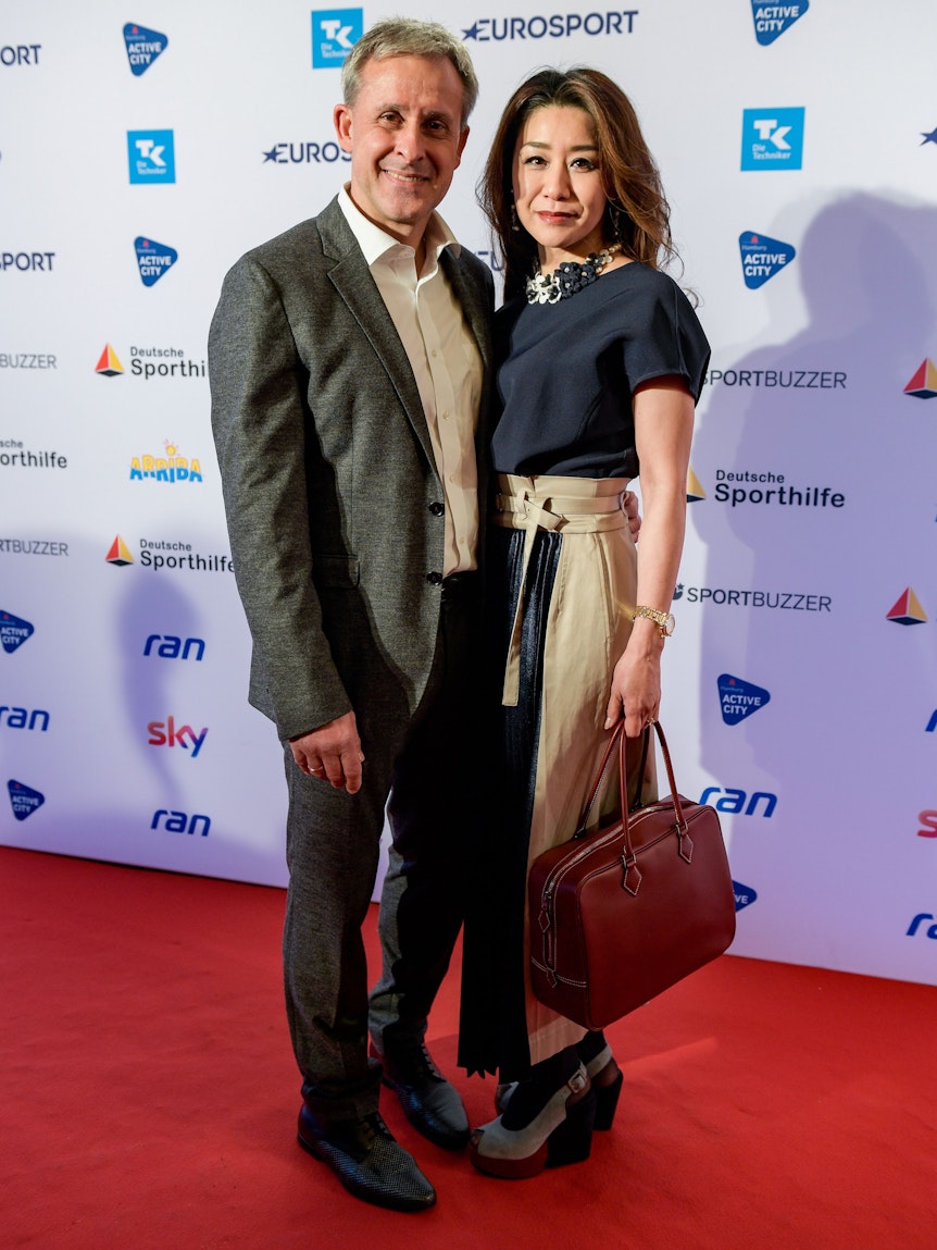 Der ehemalige Fußball-Nationalspieler Pierre Littbarski und seine Frau Hitomi stehen bei der Verleihung des Deutschen Sportjournalisten-Preises 2019 auf dem Roten Teppich des Grand Elysee Hotels.