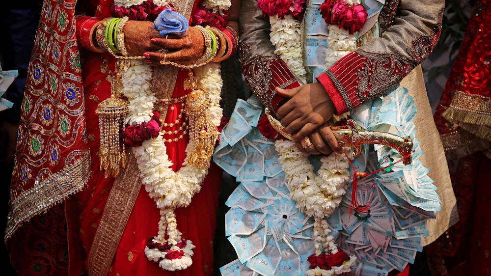 Ein frisch verheiratetes indisches Ehepaar lässt sich nach einer Gruppenhochzeit von acht Paaren fotografieren.