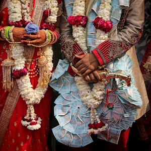 Ein frisch verheiratetes indisches Ehepaar lässt sich nach einer Gruppenhochzeit von acht Paaren fotografieren.