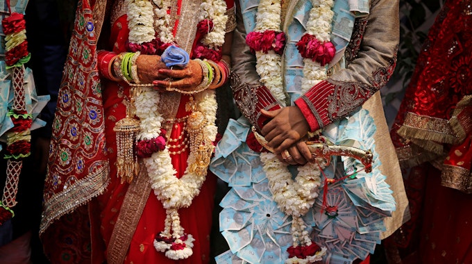 Ein frisch verheiratetes indisches Ehepaar lässt sich nach einer Gruppenhochzeit von acht Paaren fotografieren.&nbsp;