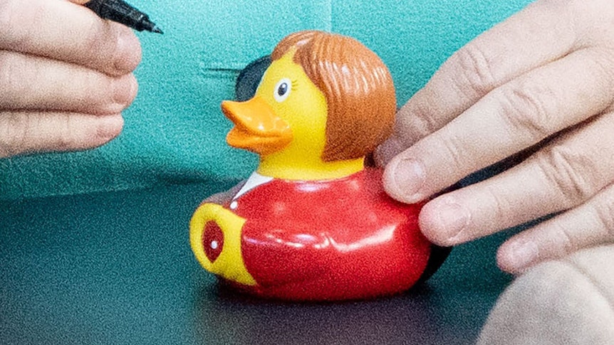 Die Berliner Künstlergruppe interDuck baute eine Badeente nach Angela Merkels Vorbild. Auf dem Foto (aufgenommen 26. September 2019) sieht man diese Ente, während sie von Bundeskanzlerin Angela Merkel (CDU) signiert wird.