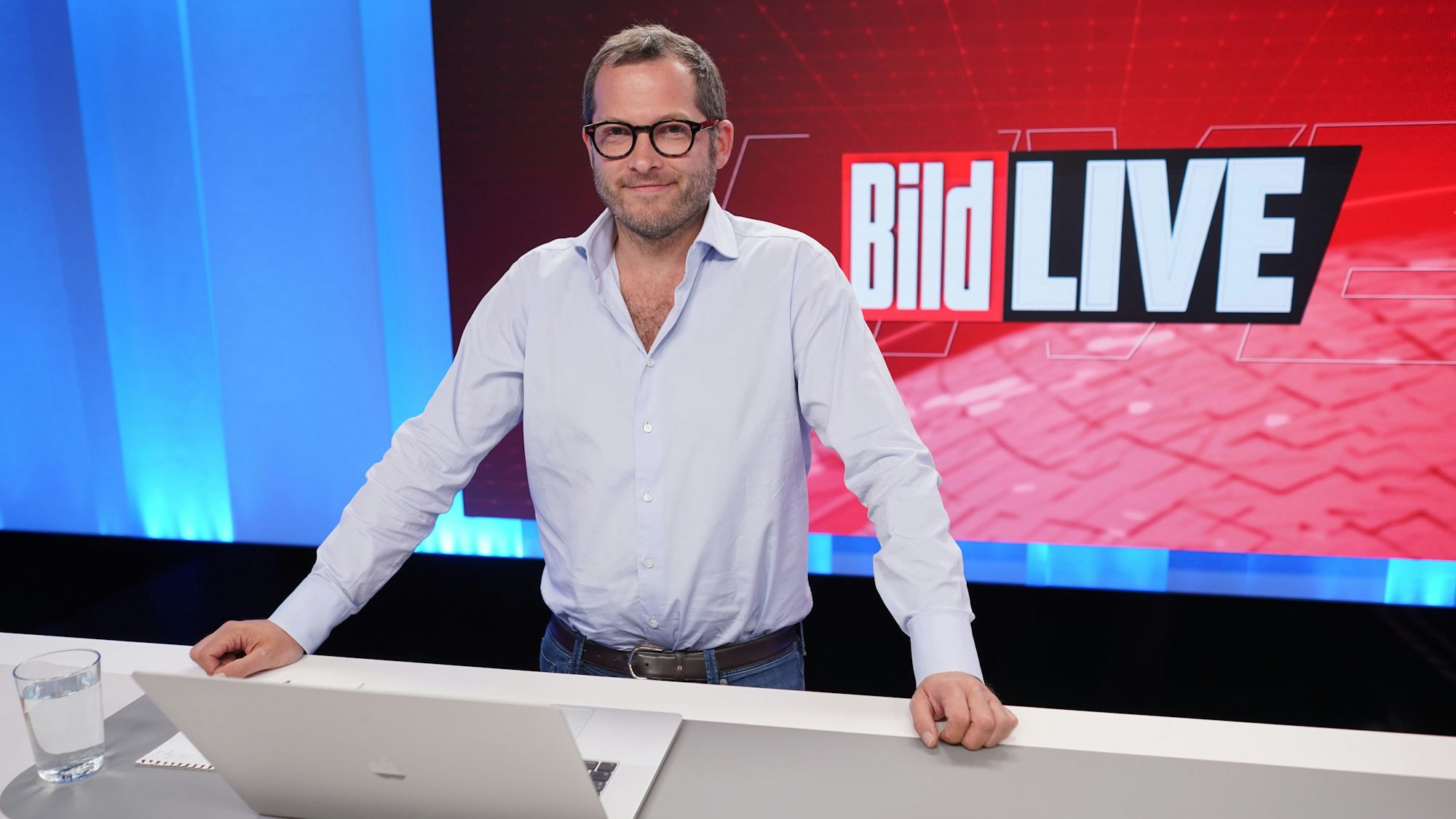 Julian Reichelt, Chefredakteur „Bild“, steht im August 2021 im Studio des TV-Senders „Bild“. Er trägt ein weißes Hemd, lächelt in die Kamera.