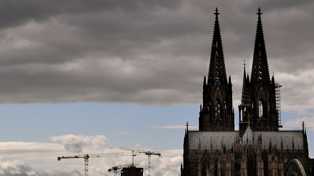 Der Kölner Dom mit seinen Turmspitzen kratzt an den dunklen Wolken.&nbsp;