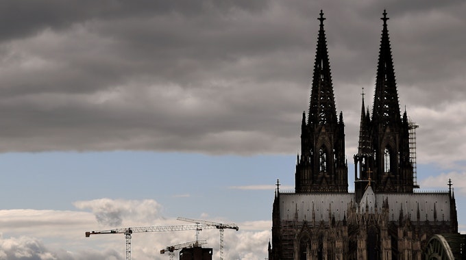 Der Kölner Dom mit seinen Turmspitzen kratzt an den dunklen Wolken.&nbsp;