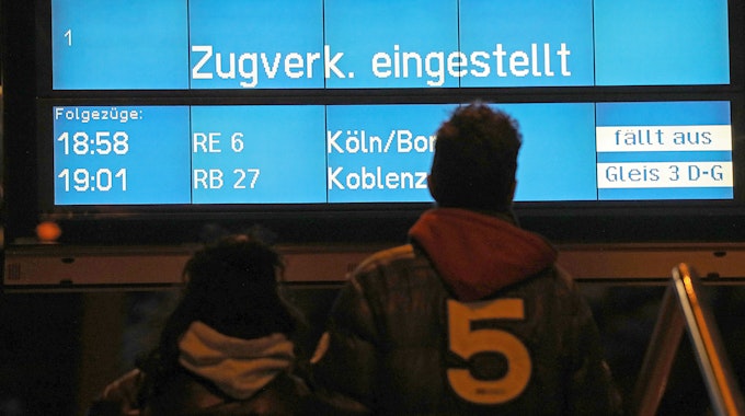Zugreisende blicken am 10. März 2019 in Köln auf eine Anzeigetafel mit dem Hinweis "Zugverkehr eingestellt". Mit Orkanböen bis Windstärke 12 hat das Sturmtief «Eberhard» den Bahnverkehr in Teilen Deutschlands zum Erliegen gebracht.&nbsp;