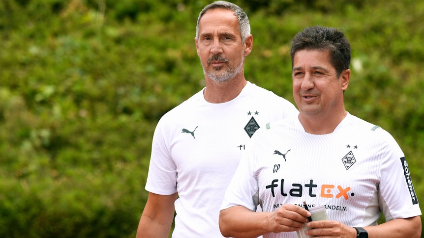 Adi Hütter, Cheftrainer von Fußball-Bundesligist Borussia Mönchengladbach, und sein Co-Trainer Christian Peintinger am 10. Juli 2021 beim Testspiel gegen Viktoria Köln im Rheydter Grenzlandstadion. Beide Trainer lächeln.