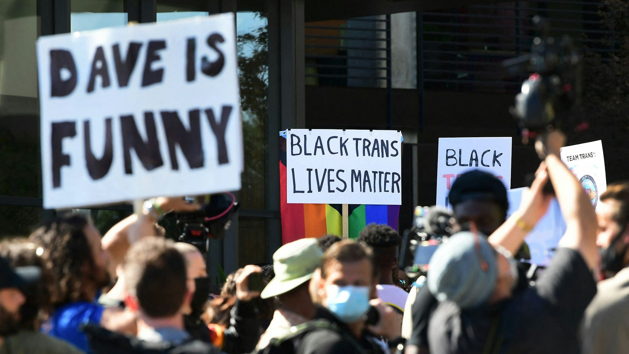 Proteste für und gegen die von einigen als transgender-feindlich empfundene Netflix-Serie „The Closer“. Auf dem Foto (aufgenommen am 20. Oktober 2021) sieht man viele Leute in Los Angeles protestieren. Auf ihren Schildern steht „Black lives matter“ oder „Dave is funny“.