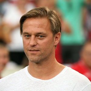 Timo Hildebrand steht vor einem Spiel des VfB Stuttgart in Zivil auf dem Rasen.