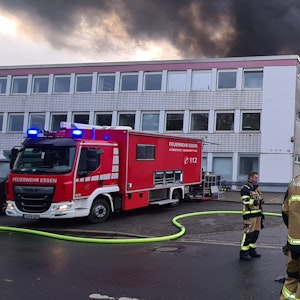 Feuerwehrleute löschen den Brand in der Lagerhalle einer Textildruckfirma.