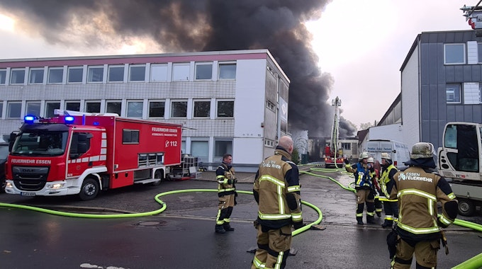 Feuerwehrleute löschen den Brand in der Lagerhalle einer Textildruckfirma.