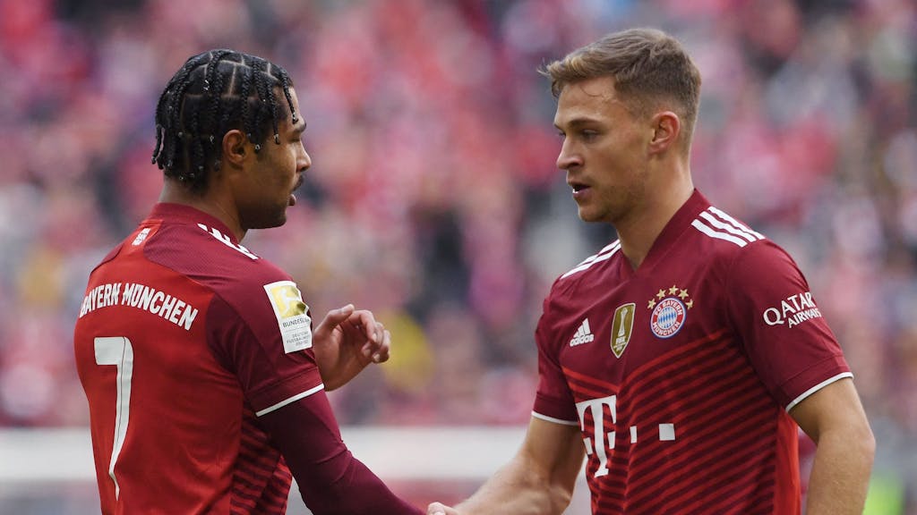 Bayern Münchens Serge Gnabry und Joshua Kimmich geben sich die Hand.