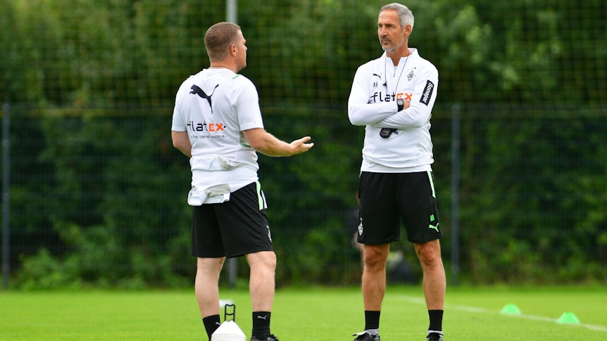 Max Eberl (l.), Manager bei Fußball-Bundesligist Borussia Mönchengladbach, unterhält sich am 21. Juli 2021 in Harsewinkel mit Cheftrainer Adi Hütter (r.). Eberl redet, Hütter hört zu.