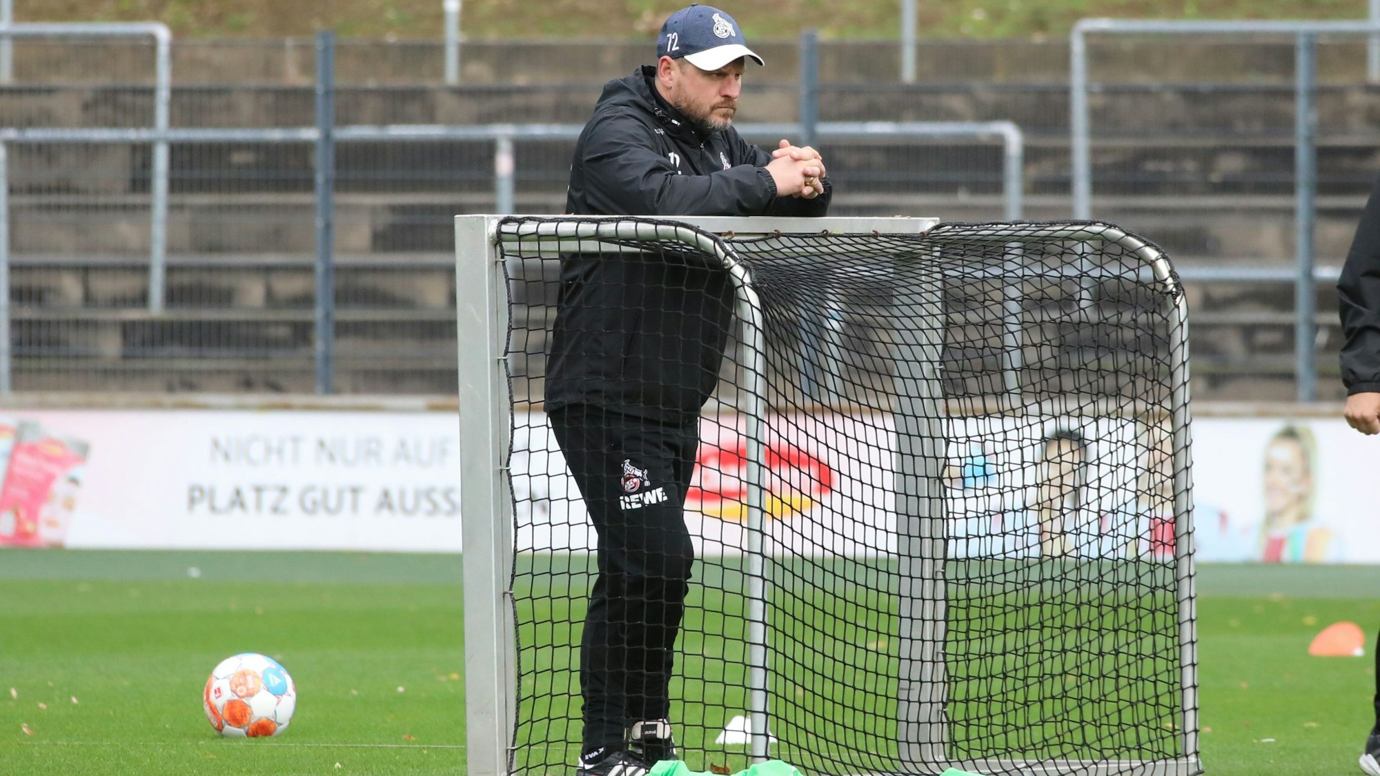 Steffen Baumgart lehnt sich im Training des 1. FC Köln auf ein kleines Fußballtor.