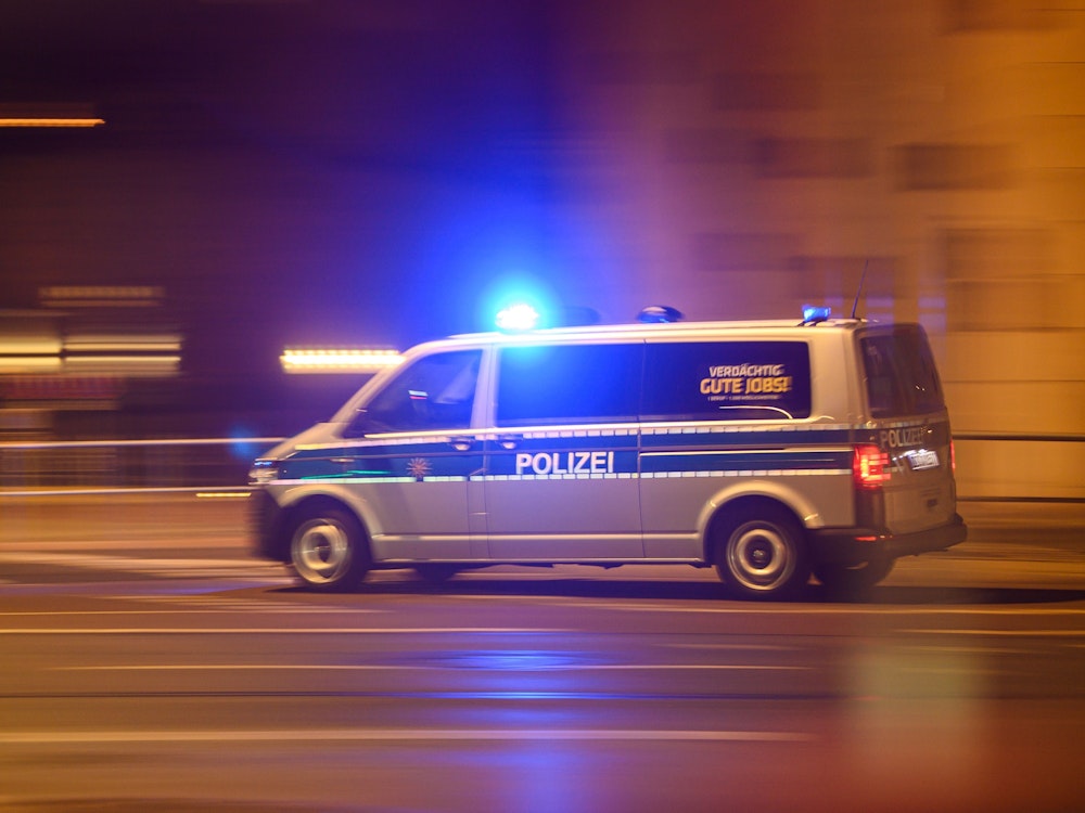 Ein Polizeiwagen mit Blaulicht fährt am Silvesterabend durch die Innenstadt zu einem Einsatz.