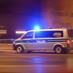 Ein Polizeiwagen mit Blaulicht fährt am Silvesterabend durch die Innenstadt zu einem Einsatz.
