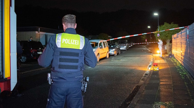 Die Polizei steht am späten Abend in Hürth im Rhein-Erft-Kreis am Tatort, an dem ein bewaffneter Mann in das Haus einer Familie eingedrungen war.