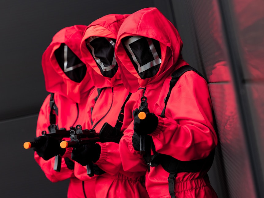 Mitarbeiter des Kostümhändlers Deiters posieren in Kostümen aus der Serie „Squid Game“ des Streaming-Anbieters Netflix.