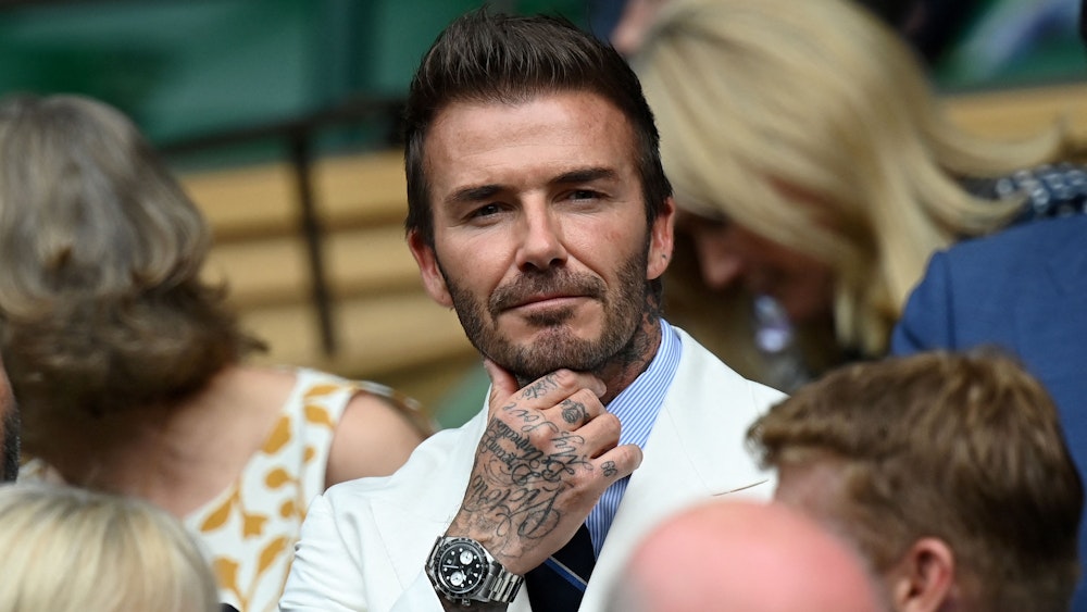 David Beckham sitzt beim Tennis-Turnier in Wimbledon auf der Tribüne.