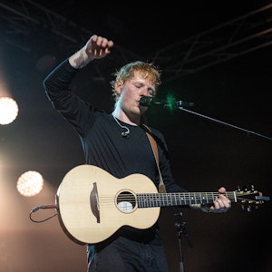 Ed Sheeran steht mit seiner Gitarre auf der Bühne.