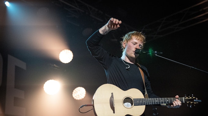 Ed Sheeran steht mit seiner Gitarre auf der Bühne.