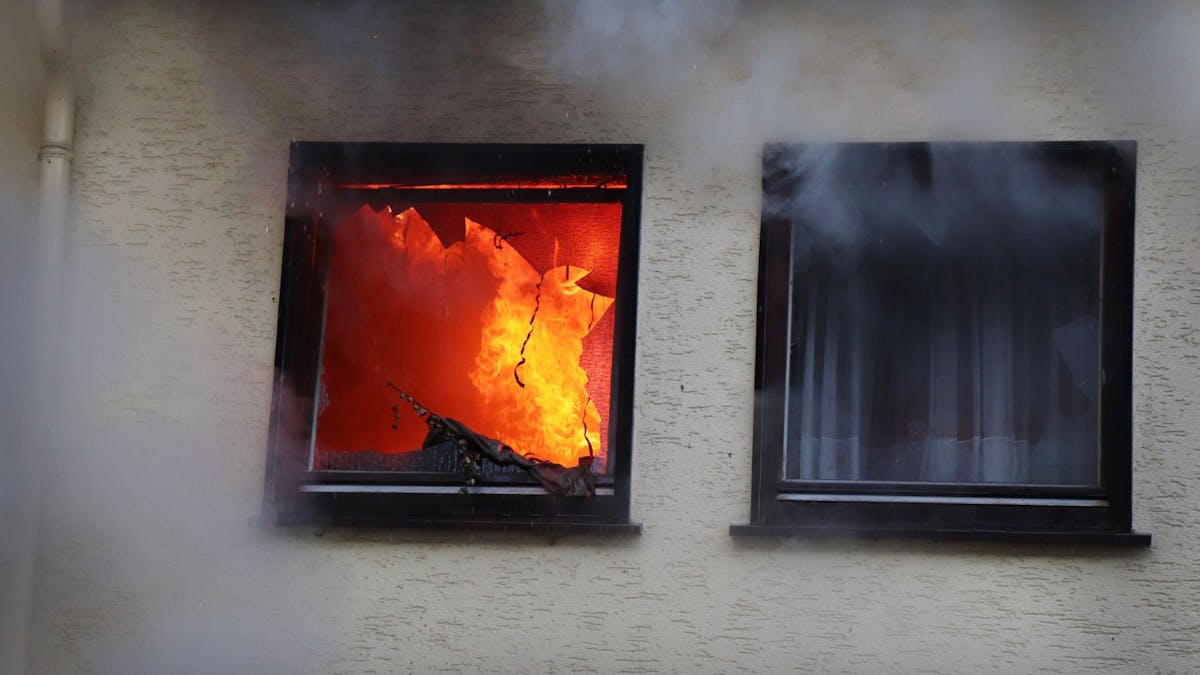Hinter einem Fenster eines Hauses in Dortmund sind am 9. Januar 2019 Flammen zu sehen.&nbsp;