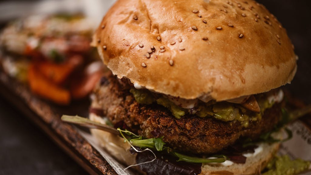 Ein veganer Burger wurde auf einem Teller angerichtet.