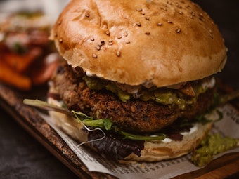 Ein veganer Burger wurde auf einem Teller angerichtet.