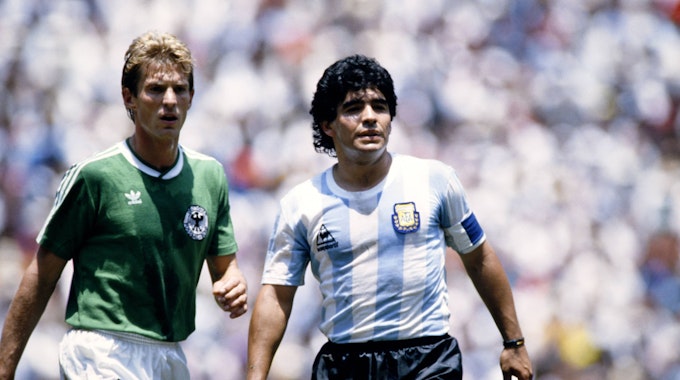 Links Karlheinz Förster im grünen Deutschland-Trikot, rechts Diego Armando Maradona in blau-weiß gestreiften Argentinien-Trikot.