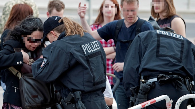Eine Polizisten führt am Mauerpark in Berlin eine Taschenkontrolle durch.&nbsp;