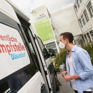 Ein junger Mann am 24. September 2021 in Düsseldorf vor einer mobilen Impfberatung.