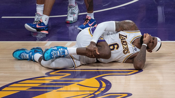 LeBron James fasst mit schmerzverzerrtem Gesicht an sein Bein.