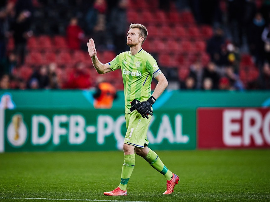 Lukas Hradecky von Bayer Leverkusen hebt entschuldigend die Hand.
