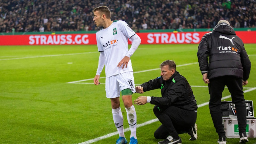 Jordan Beyer von Borussia Mönchengladbach wird im Spiel gegen Bayern München am 27. Oktober 2021 an der Seitenlinie behandelt.