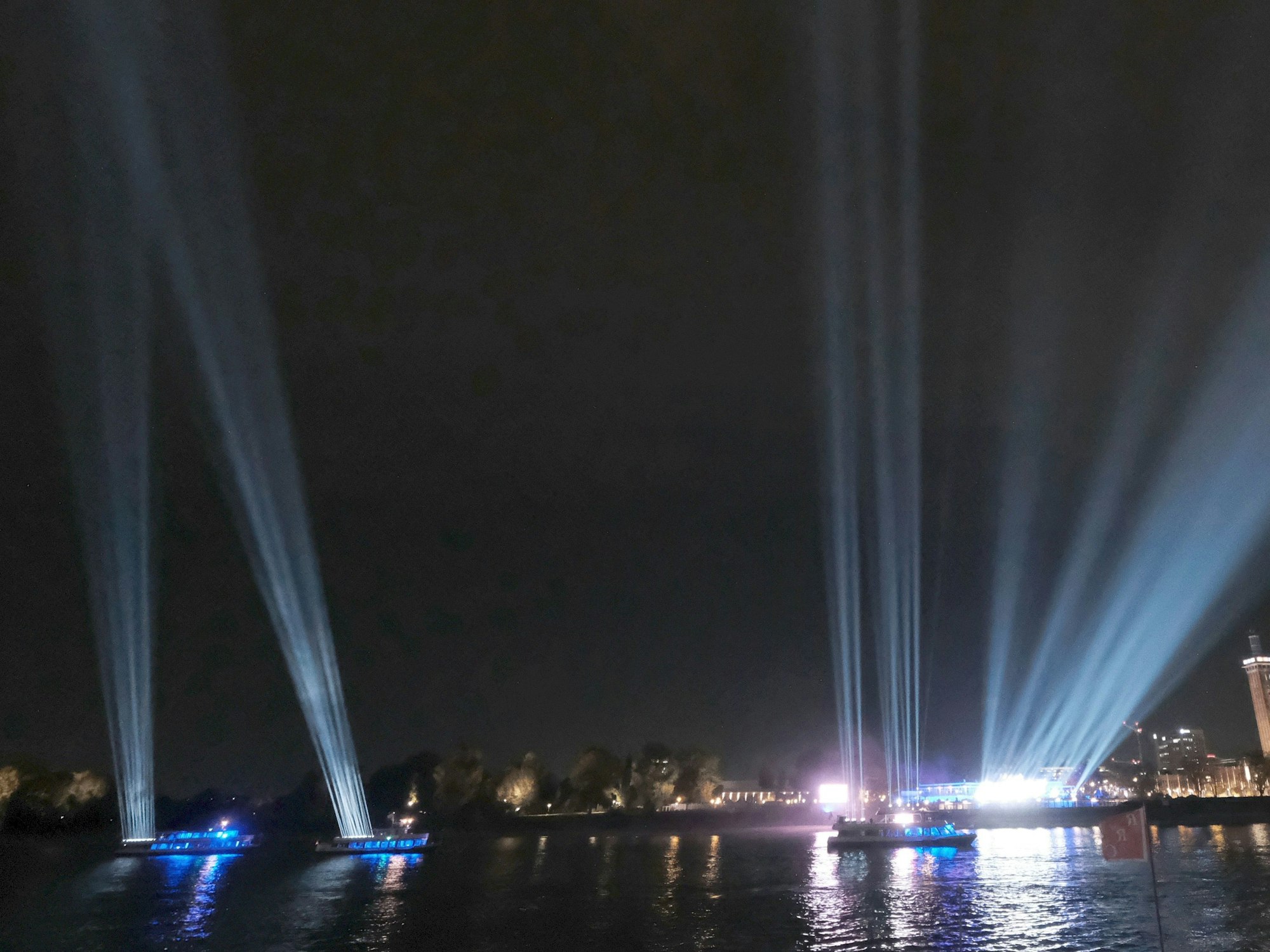 Was für eine Strahlkraft! Schiffe machen am 29. Oktober 2021 auf dem Rhein bei Köln auf das 401-jährige Firmen-Jubiläum von DuMont aufmerksam und lassen den Himmel erleuchten.