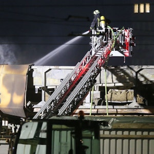 Ein Feuerwehrmann löscht am 1. April 2021 in Düsseldorf von einer Drehleiter aus Glutnester auf dem Dach einer Halle.