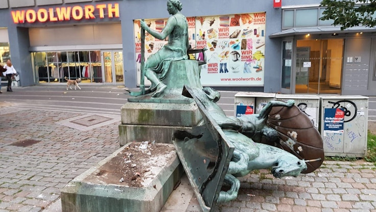 Eine Figur des Schifffahrtsbrunnens am Wiener Platz liegt auf dem Boden.