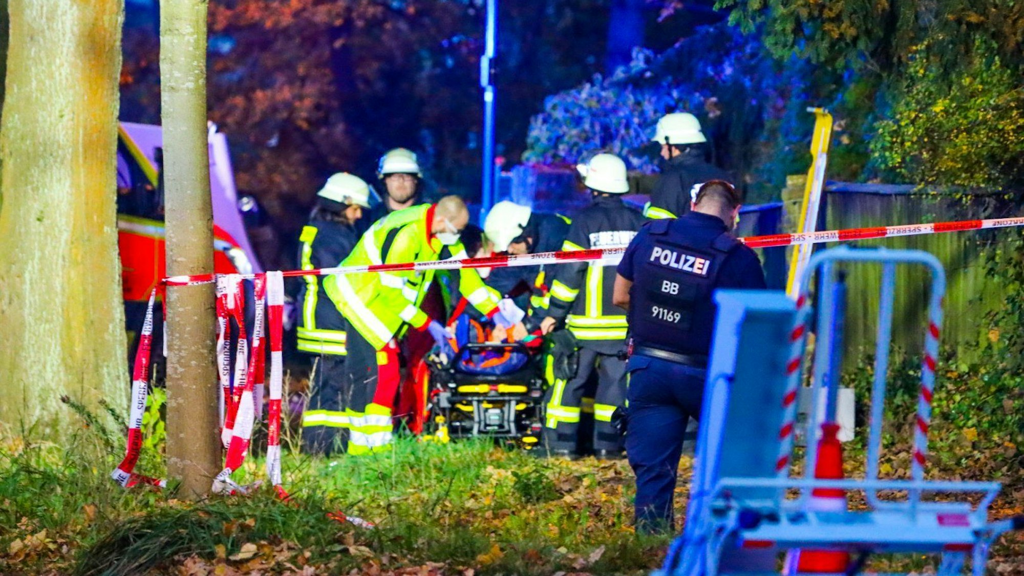Sanitäter und Feuerwehrleute stehen an der Unfallstelle in Schildow, wo am Sonntagabend eine Fußgängergruppe von einem Auto erfasst wurde.