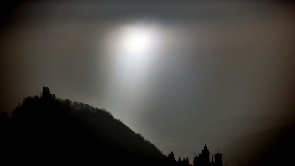 Die Sonne scheint am 28.11.2014 in Königswinter bei Bonn (Nordrhein-Westfalen) zwischen der Burg (l) und dem Schloss Drachenfels durch Nebelschwaden hindurch.