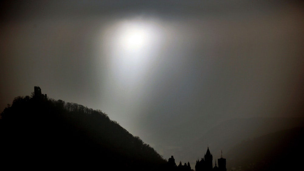 Die Sonne scheint am 28.11.2014 in Königswinter bei Bonn (Nordrhein-Westfalen) zwischen der Burg (l) und dem Schloss Drachenfels durch Nebelschwaden hindurch.