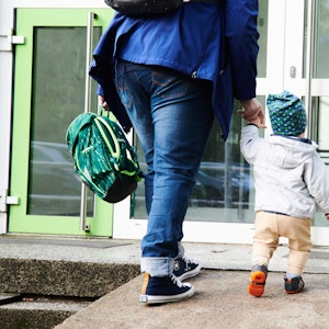 Ein Kind und seine Mutter gehen am 17. Mai 2021 zum Eingang einer Kita in Berlin.