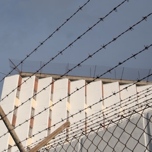In Russland ist Gewalt in Gefängnissen keine Seltenheit. Ein Ex-Insasse und ein Menschenrechtler veröffentlichen Videoaufnahmen der Folter. Das Symbolfoto (aufgenommen am 2. Oktober 2021) zeigt ein Gebäude der Justizvollzugsanstalt Stuttgart-Stammheim, die Mauer wird mit einem Stacheldrahtzaun umschlossen.