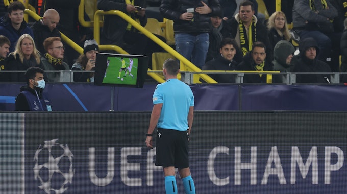 Schiedsrichter Michael Oliver prüft per Videobeweis eine Entscheidung im Spiel zwischen Borussia Dortmund und Ajax Amsterdam.