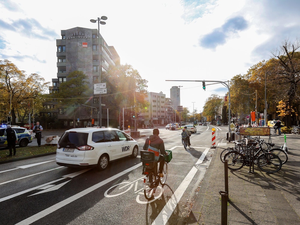 Eine Fahrradfahrerin steht an einer Ampel in Köln.