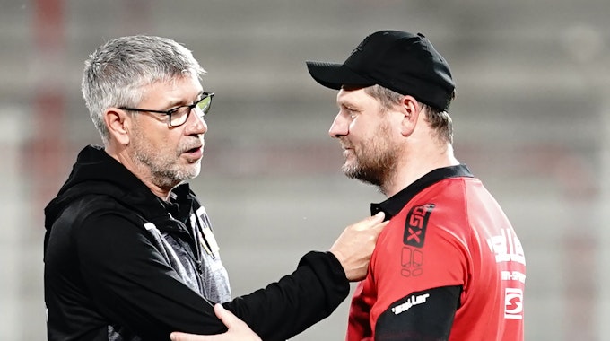 Berlins Trainer Urs Fischer und Paderborns Trainer Steffen Baumgart (r) unterhalten sich nach dem Spiel.