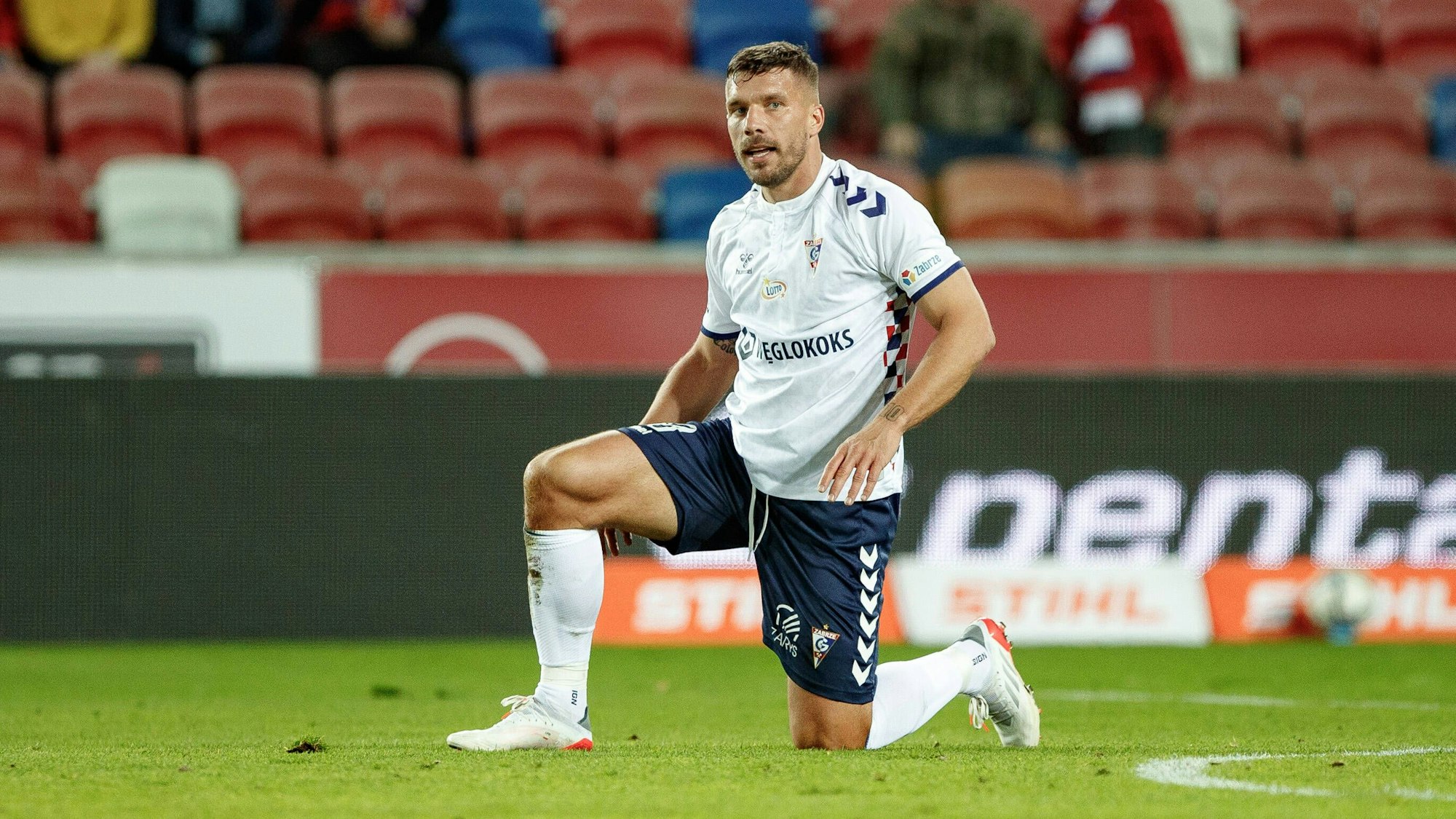 Lukas Podolski kniet auf dem Rasen