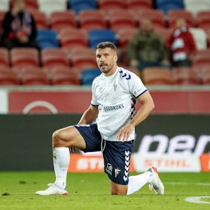 Lukas Podolski kniet auf dem Rasen