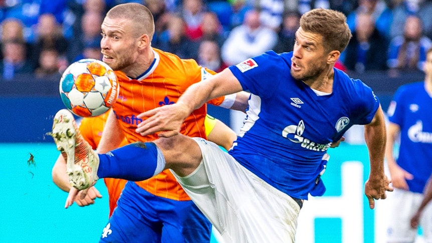 Darmstadts Thomas Isherwood (l) und Schalkes Simon Terodde kämpfen um den Ball.
