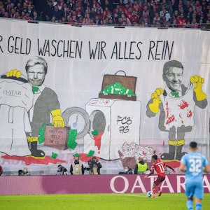 Mit einem Transparent „Für Geld waschen wir alles rein“ protestieren Fans von Bayern München gegen die Geschäftsbeziehungen des Rekordmeisters mit Katar.