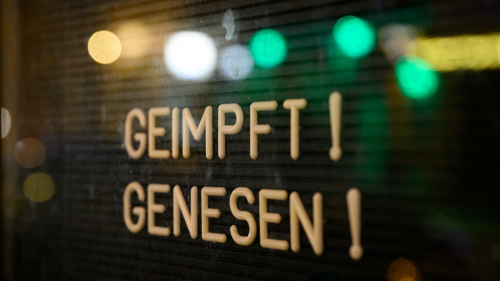 Auf dem Symbolfoto (aufgenommen am 6. November 2021) ist ein Schaukasten zu sehen, in welchem ein Schild mit der Aufschrift „Geimpft! Genesen!“ steht.